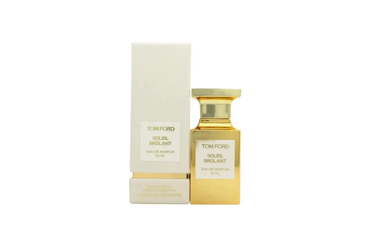 Złota butelka perfum Tom Ford Soleil Br&ucirc;lant, emanująca ciepłem, obok swojego eleganckiego, kremowego opakowania.