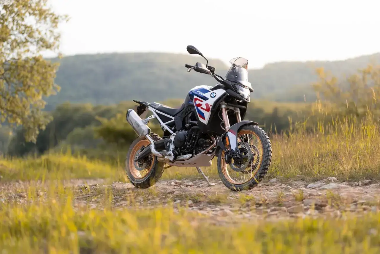 BMW F900GS gotowy na przygodę na leśnej ścieżce.