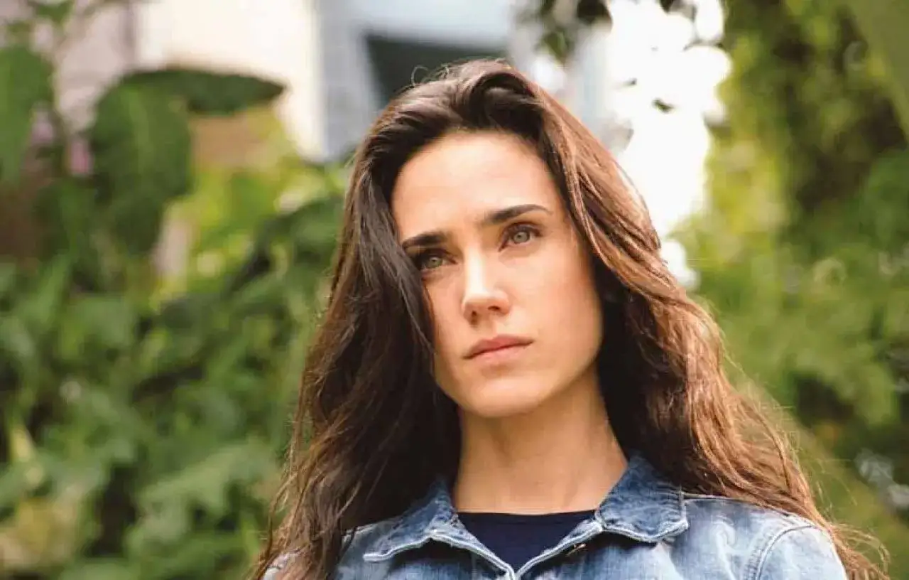 Jennifer Connelly w dżinsowej kurtce, zamyślona. Aktorka znana z wielu filmów, w tym 