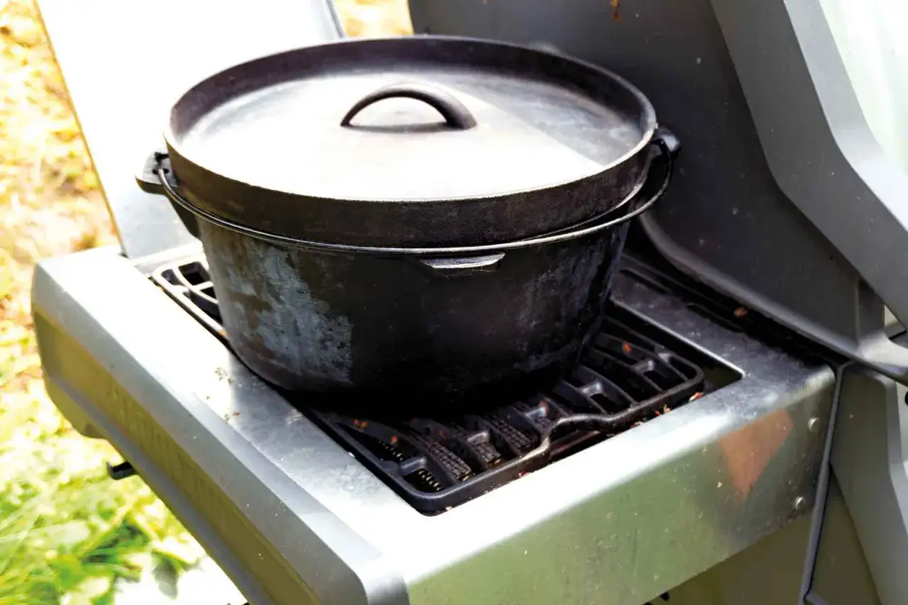 Schwarzer Gusseisen-Dutch Oven auf einem Gasgrill, bereit f&uuml;r k&ouml;stliche Dutch Oven Rezepte.