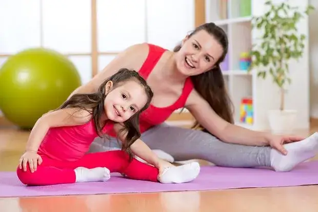 dzieci wykonujące jogę lub dynamiczne ćwiczenia r&oacute;wnoważne