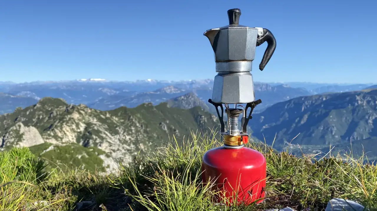 En kaffebryggare på en gasbehållare, redo för en optimus hiker att njuta av en kopp med bergsvy.