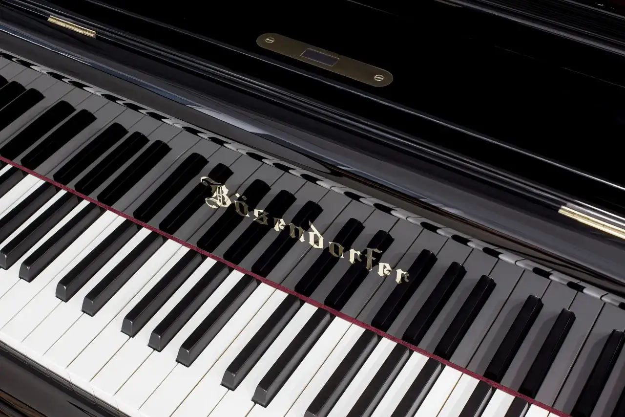 Bösendorfer z 92 klawiszami. Lśniąca, czarna obudowa i złote logo.