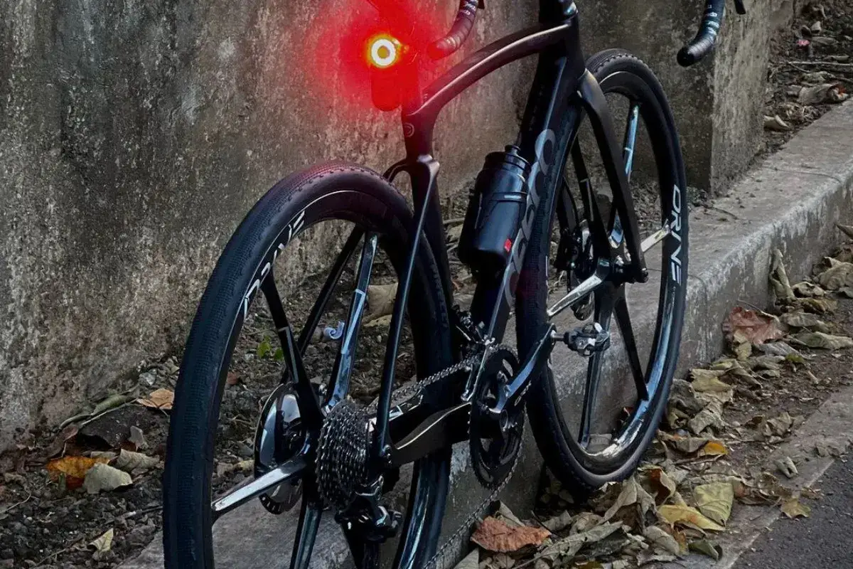 Czarny rower szosowy z czerwoną lampką. Czy to rower gravel? Nie, to szosa gotowa na asfalt.