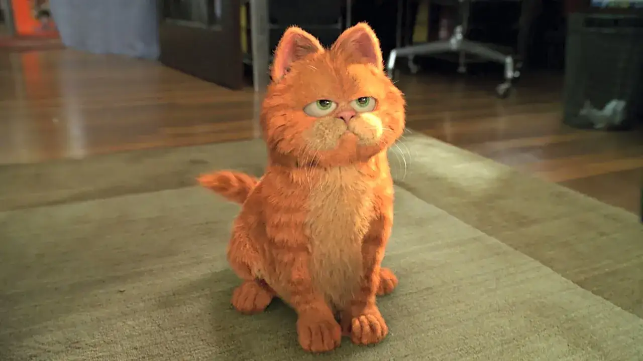 Pomarańczowy Garfield, jeden z najbardziej znanych kotów, siedzi na dywanie, patrząc z lekko znudzonym wyrazem twarzy.