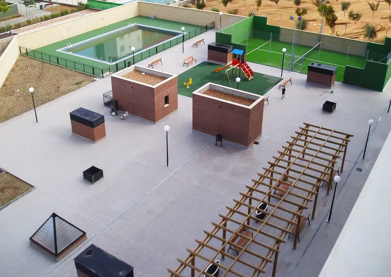 Vista a&eacute;rea de un condominio vivienda con piscina, zona infantil, cancha deportiva y p&eacute;rgola.