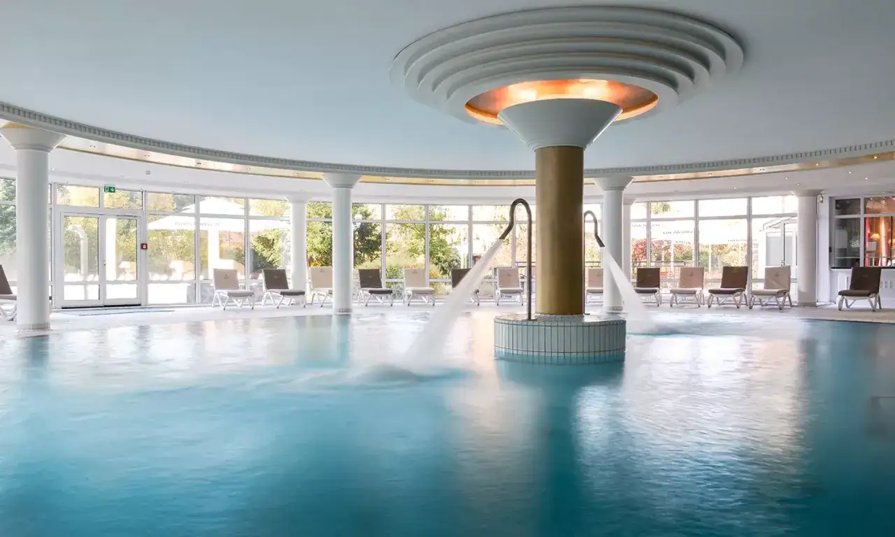 Entspannende Wasserfont&auml;nen sprudeln in einem Innenpool. Liegest&uuml;hle laden zum Verweilen ein. Ein Ort der Ruhe in der Therme Regensburg.