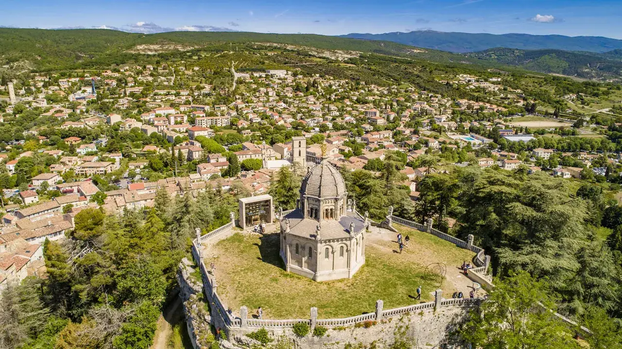 Vue a&eacute;rienne de la citadelle de Forcalquier, avec son d&ocirc;me imposant et le village proven&ccedil;al s'&eacute;tendant &agrave; flanc de colline.