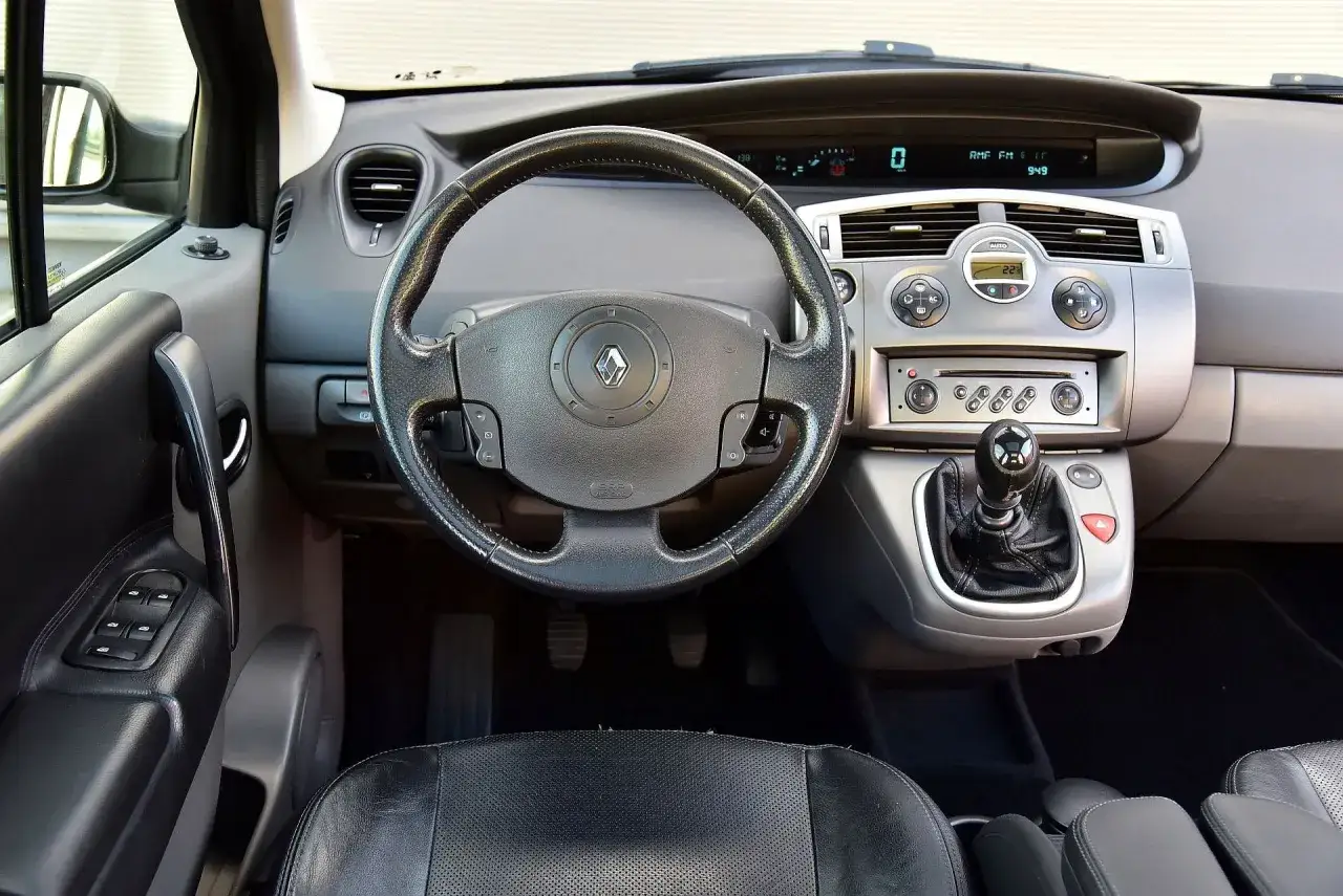 Wnętrze Renault Scenic 2: kierownica, deska rozdzielcza z radiem i nawiewami, dźwignia zmiany biegów.