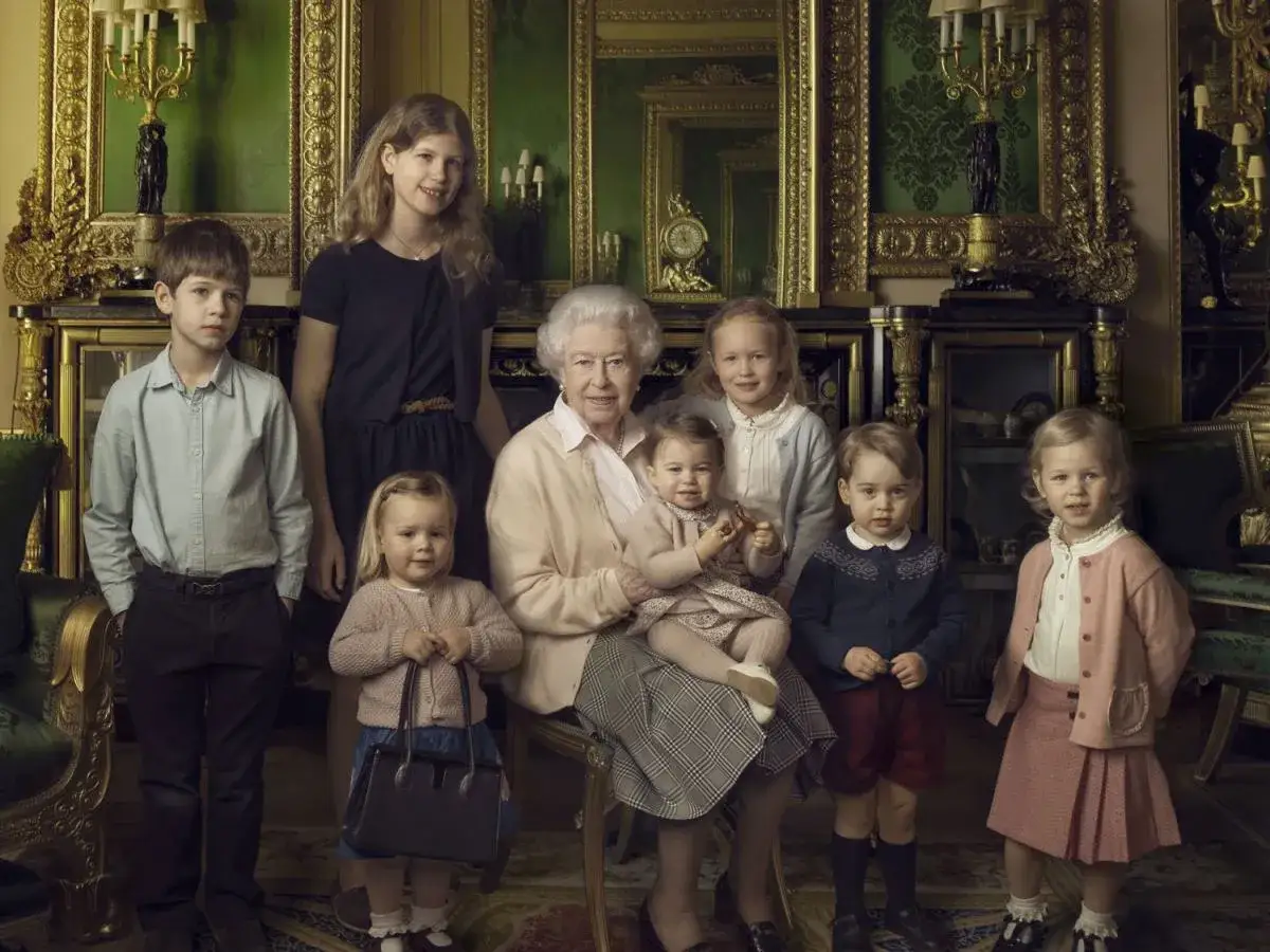 Elżbieta II z wnukami, w tym z księciem George'em i księżniczką Charlotte, w eleganckim wnętrzu.