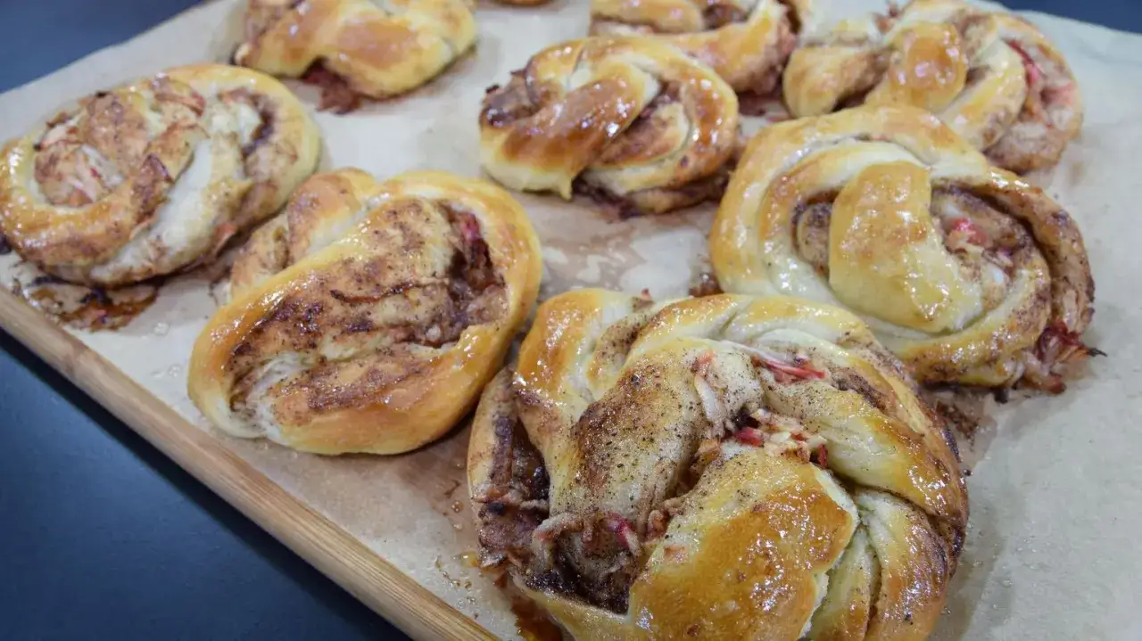 Nybakade kanelbullar med &auml;pple, gyllene och glansiga, redo att avnjutas.