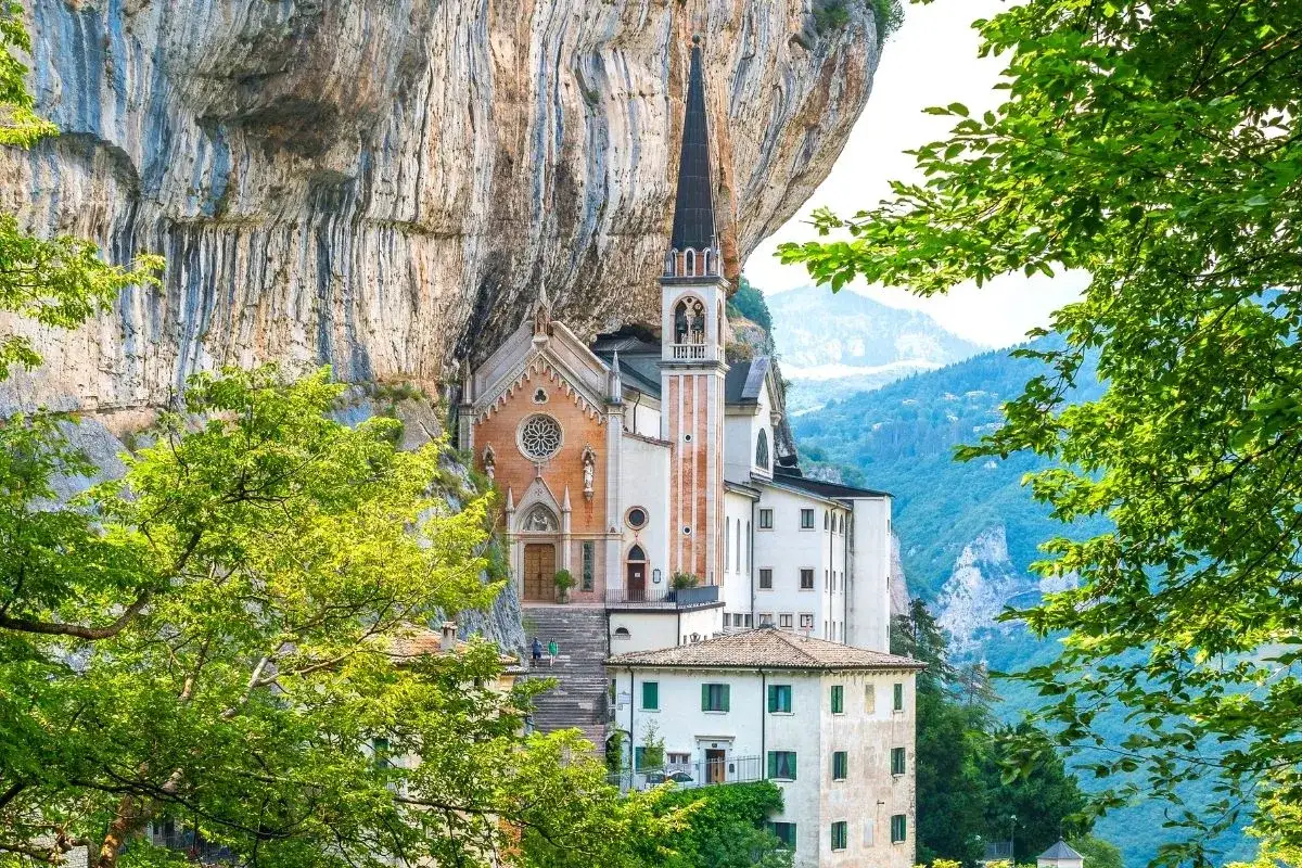 Suggestiva chiesa incastonata nella roccia, un gioiello architettonico con vista sulle montagne. Un luogo di pace e bellezza, vicino al Lago di Garda.