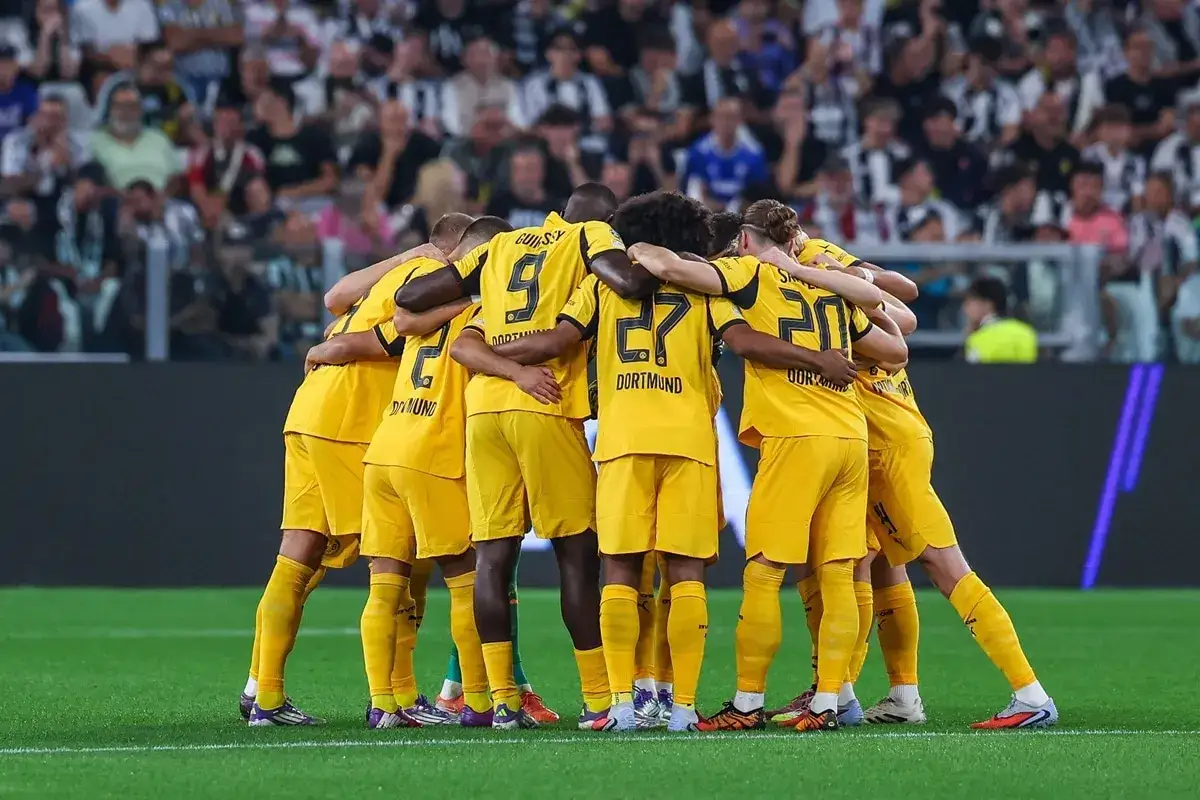 Piłkarze Borussii Dortmund w żółtych strojach tworzą zwarty krąg. Czekają na kolejne borussia dortmund transfery, by wzmocnić drużynę.