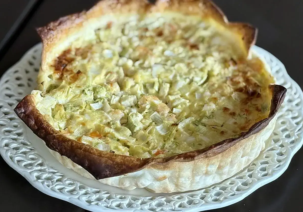 Delicioso pastel de verduras con masa dorada y relleno cremoso.