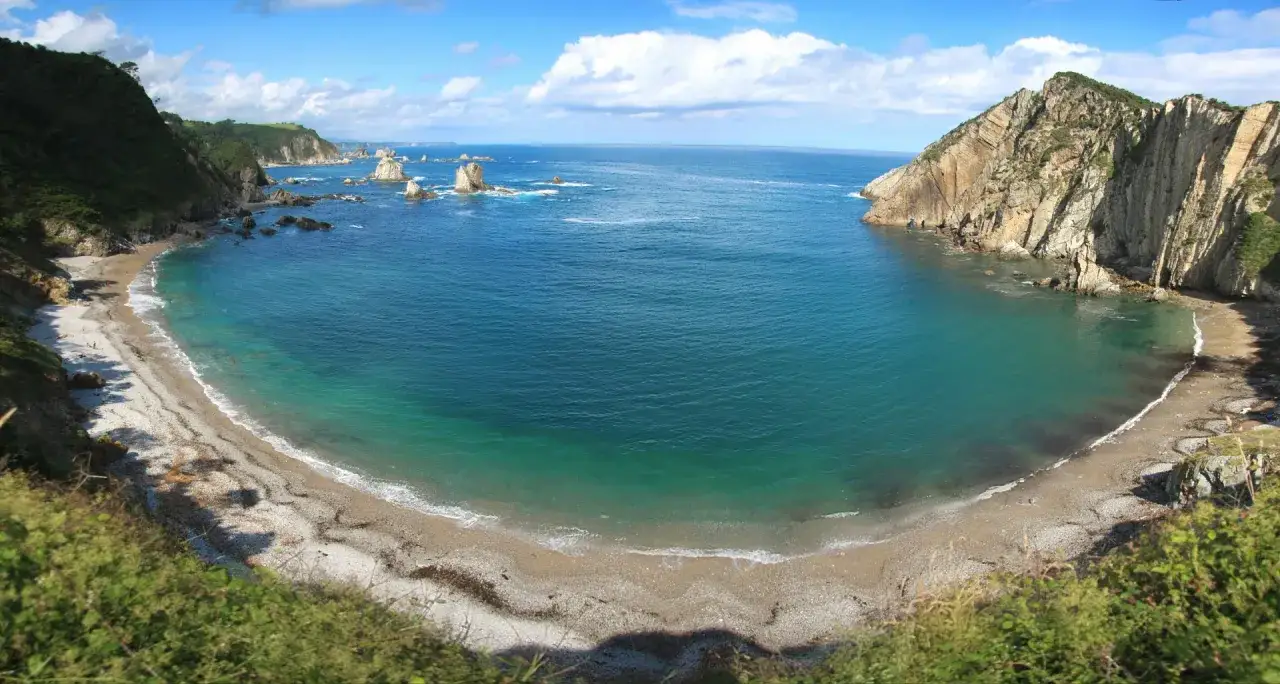 La **playa del Silencio, Asturias**, es una joya escondida entre acantilados verdes y rocas que emergen del mar turquesa.