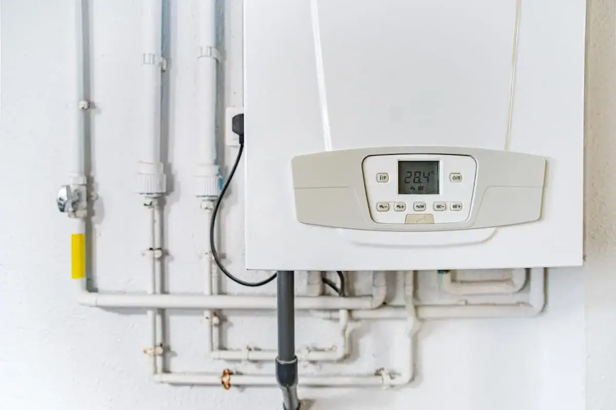 Installation d'un thermostat connecté pour chaudière gaz. Le boîtier blanc affiche 28.4°C.
