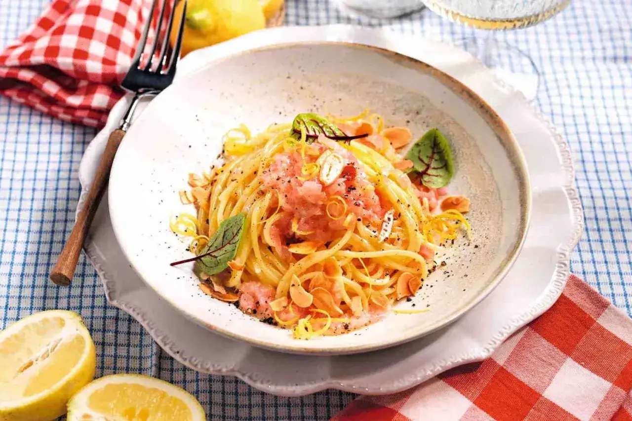 Spaghetti conditi con sughi in bianco leggeri, arricchiti da scorza di limone e guarniti con erbe fresche.