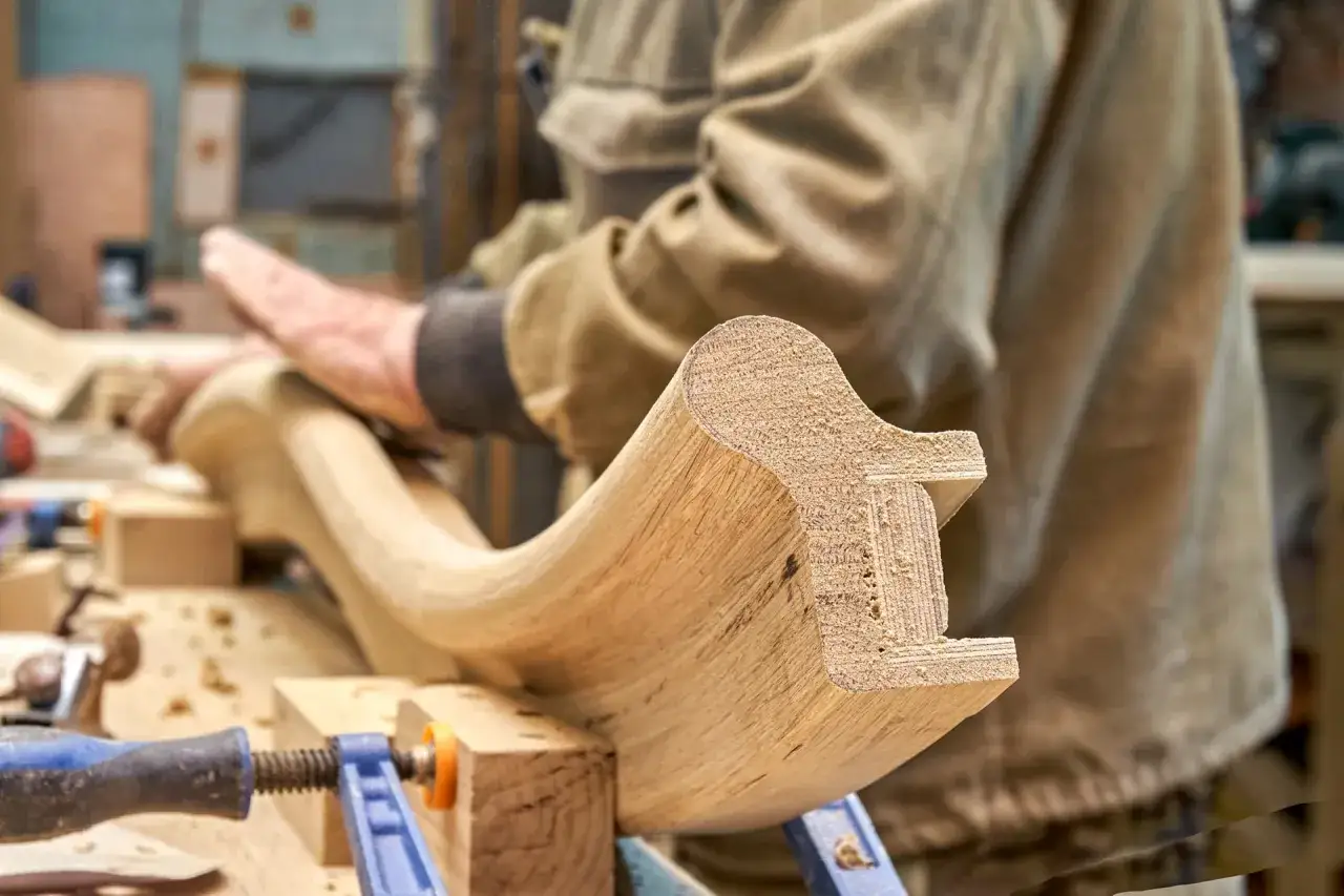 Carpintero lijando pieza de madera para restaurar muebles antiguos.