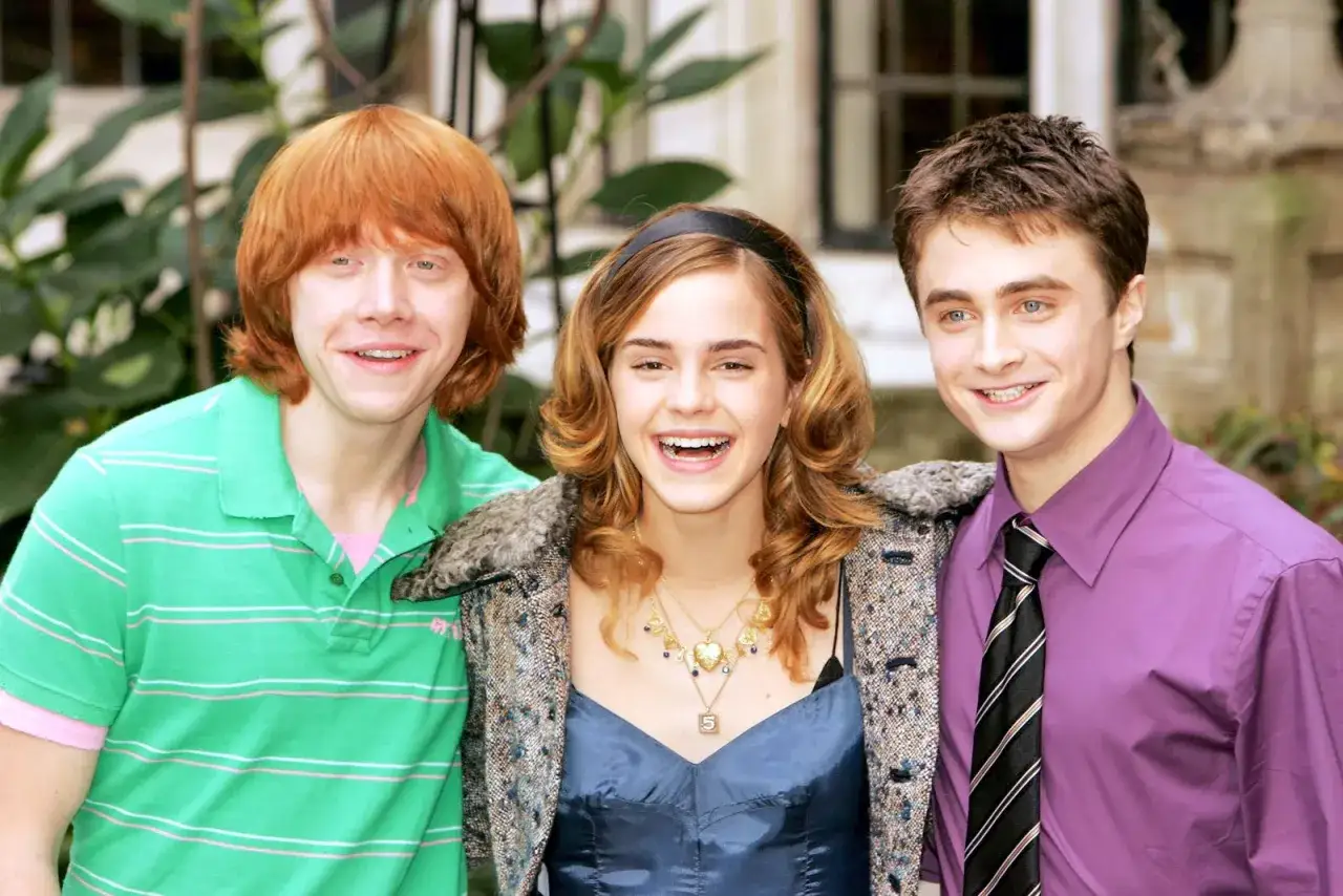 Harry, Ron och Hermione, tre &auml;lskade figurer i Harry Potter, ler glatt.
