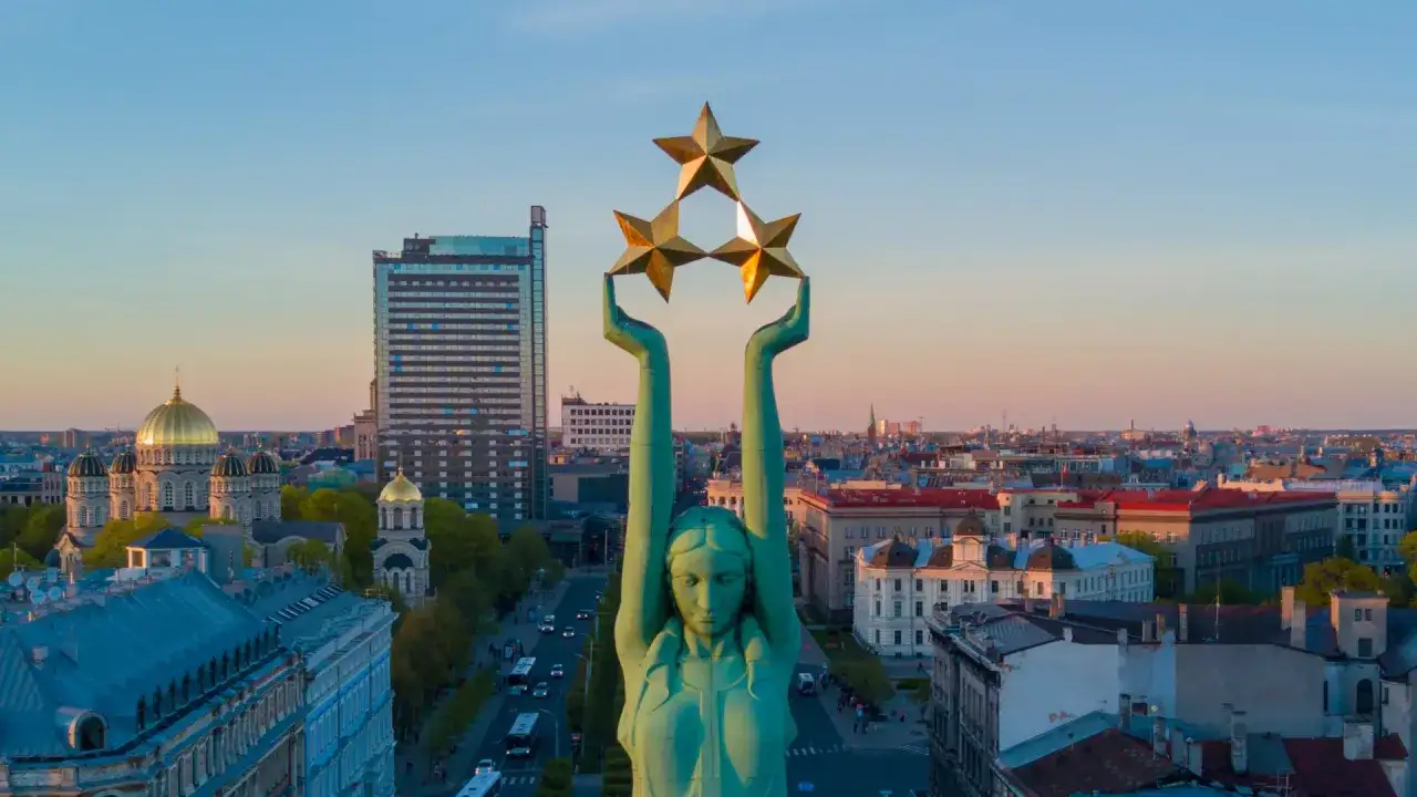 Frihetsmonumentet i Riga med sina tre gyllene stj&auml;rnor reser sig &ouml;ver staden.