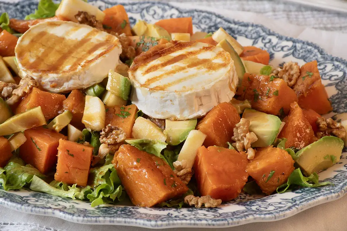 Deliciosa ensalada de batata asada con queso de cabra a la parrilla, aguacate, manzana y nueces.