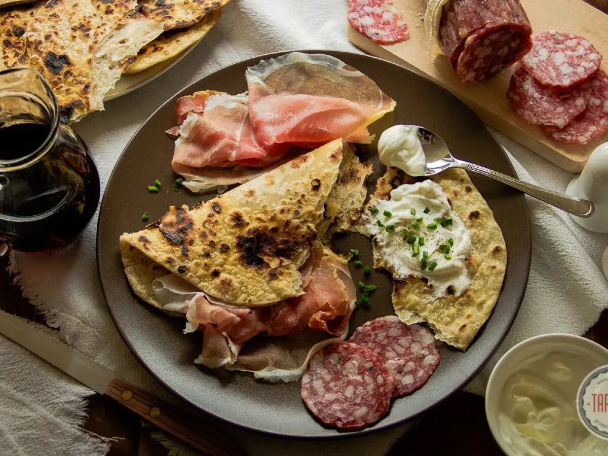 Pyszna piadina z szynką parmeńską, salami i kremowym serkiem. Idealna na włoską przekąskę.