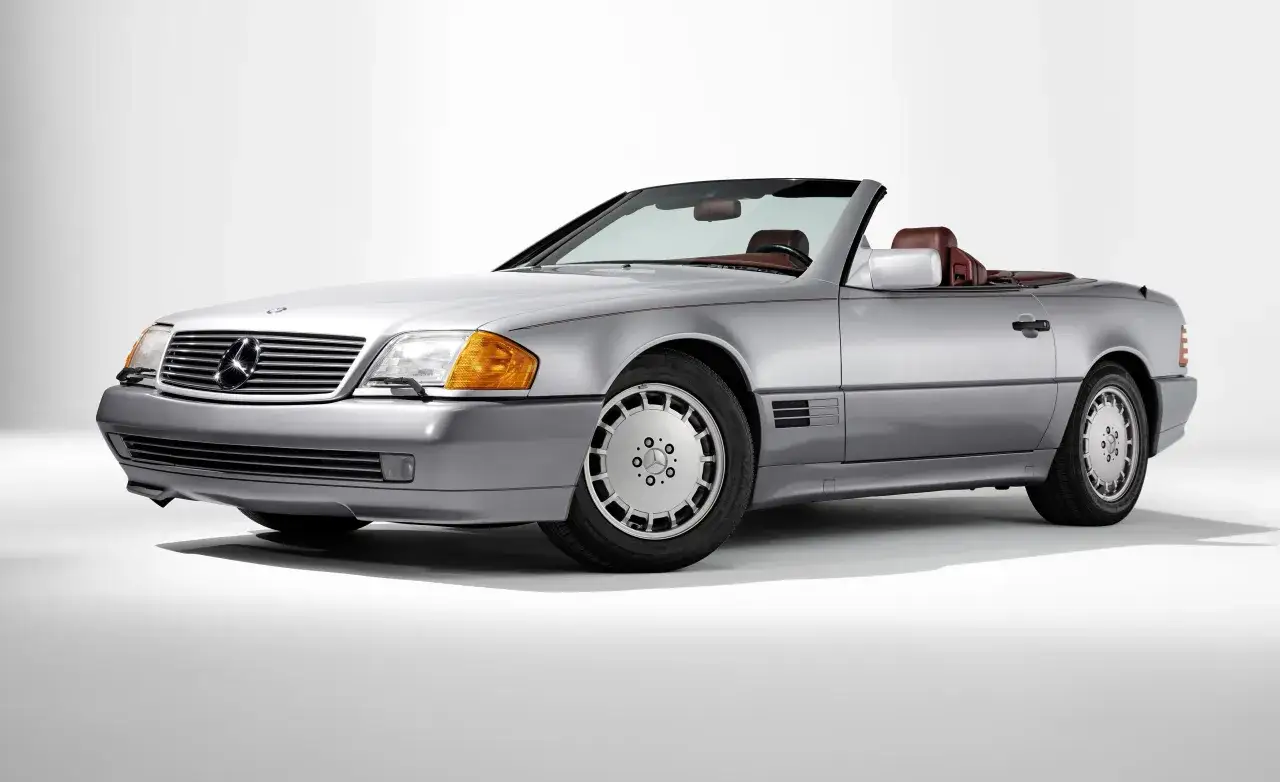 Srebrny kabriolet Mercedes-Benz SL500 z brązową skórzaną tapicerką, gotowy na letnią przejażdżkę.