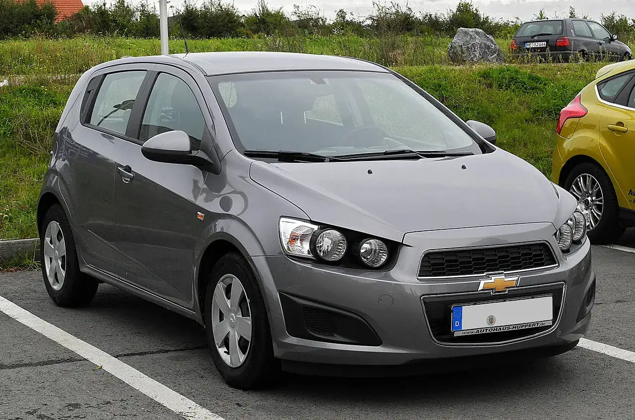 Szary Chevrolet Aveo na parkingu. Wiele osób szuka chevrolet aveo opinie przed zakupem.