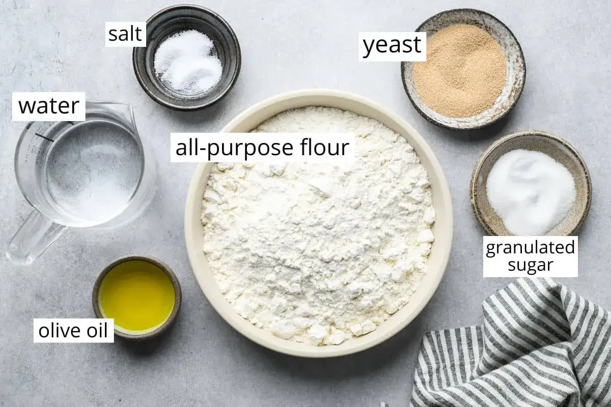Zutaten für pizzateig selber machen: Mehl, Wasser, Hefe, Salz, Zucker, Olivenöl.