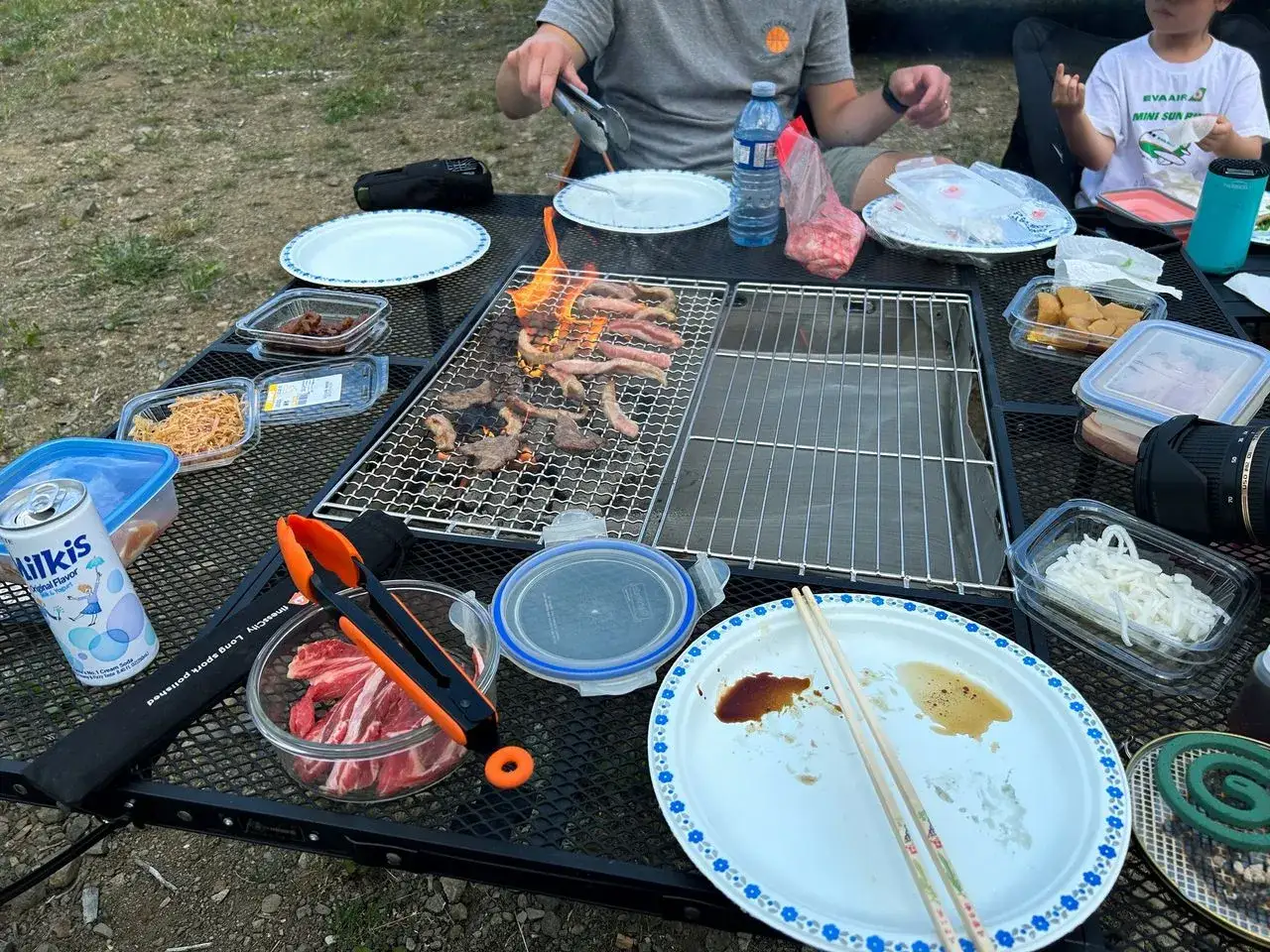 Rodzinny grill, gdzie mięso skwierczy na ogniu. To właśnie **bbq co to znaczy** &ndash; wsp&oacute;lne jedzenie i radość na świeżym powietrzu.