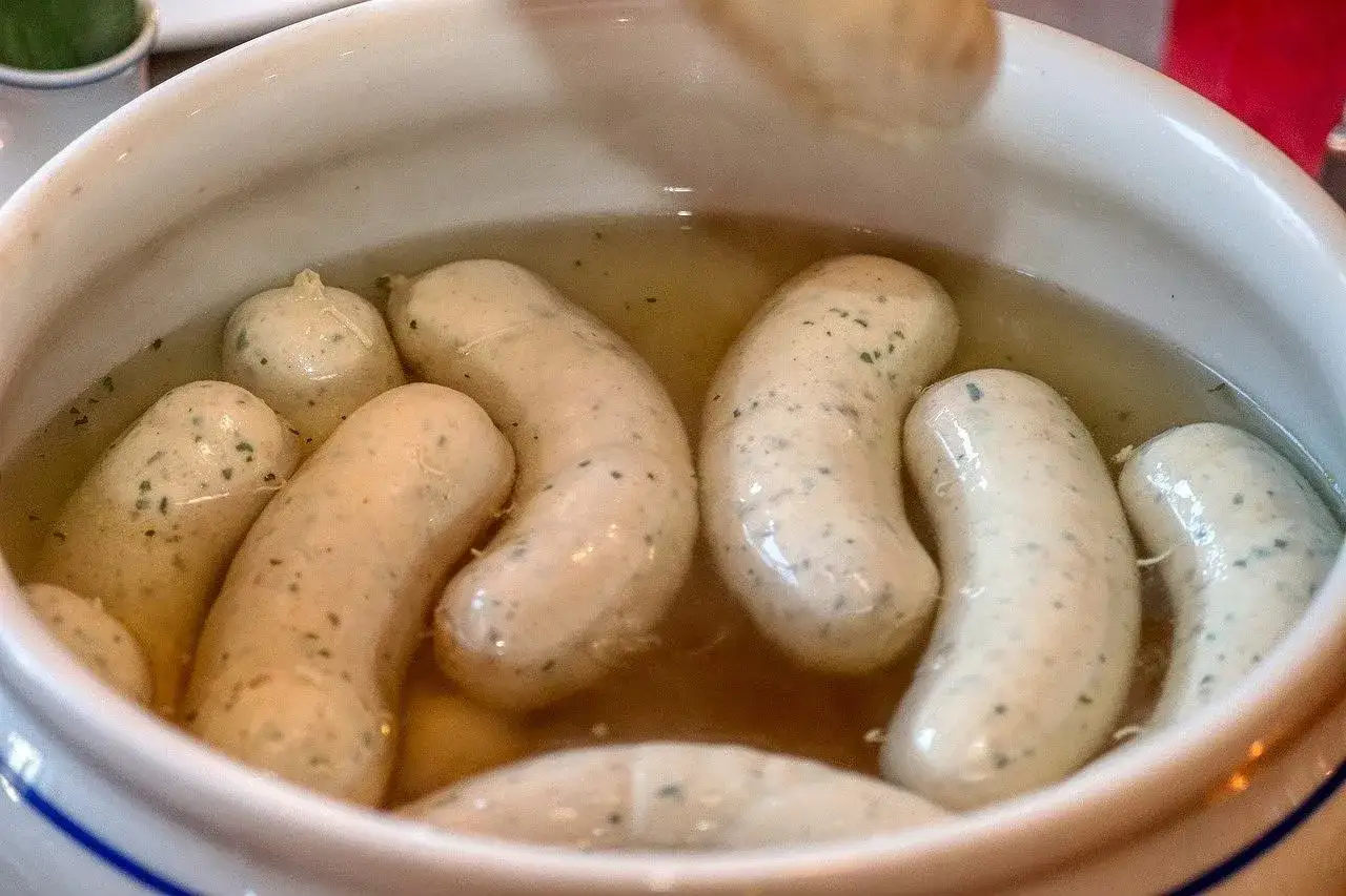 Biała kiełbasa gotuje się w bulionie. Idealny sposób, jak ugotować białą kiełbasę, by była soczysta i aromatyczna.