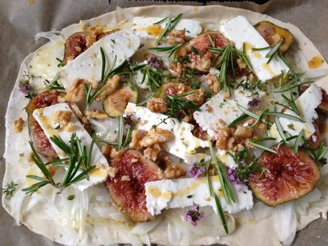 Feigen Flammkuchen mit Ziegenkäse, Walnüssen und Rosmarin, beträufelt mit Honig.