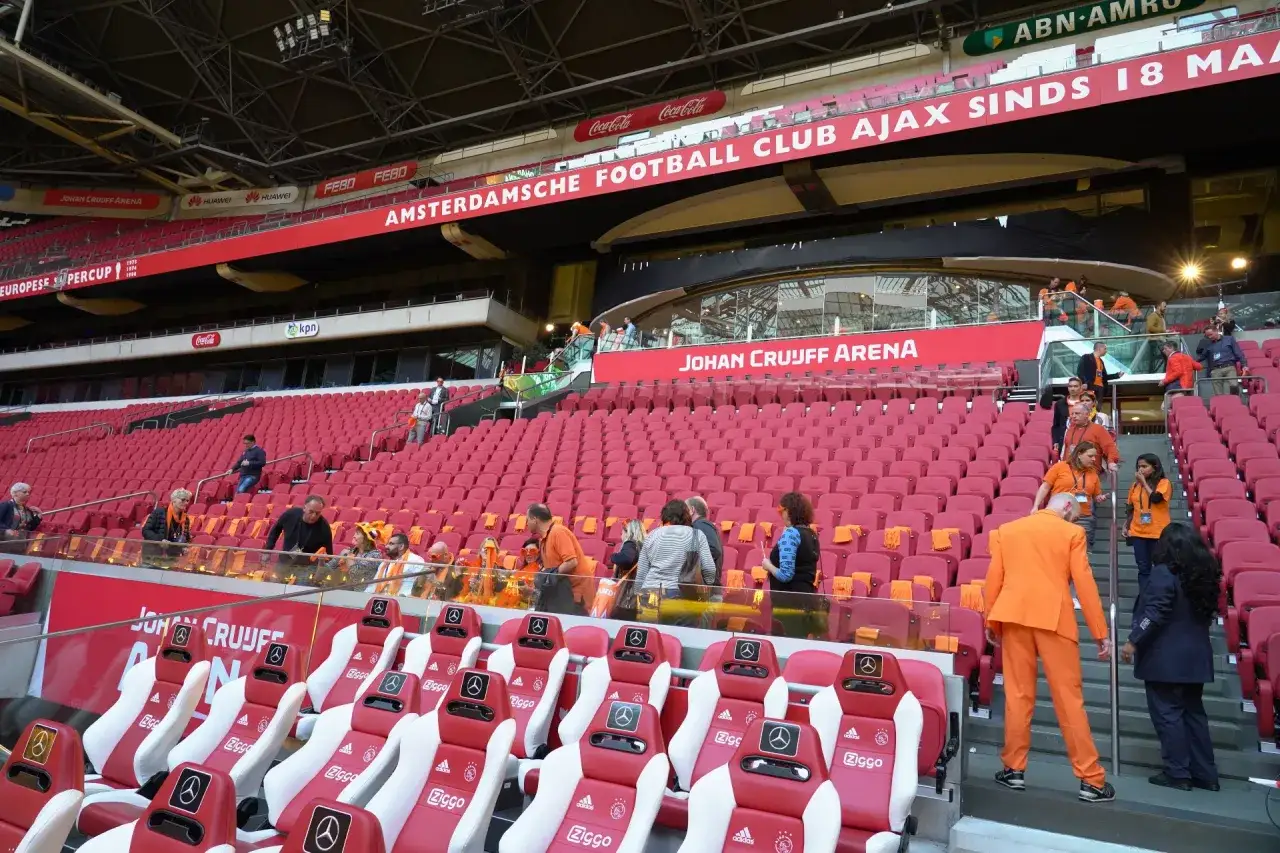 Puste czerwone trybuny Johan Cruyff Arena, z widocznymi napisami