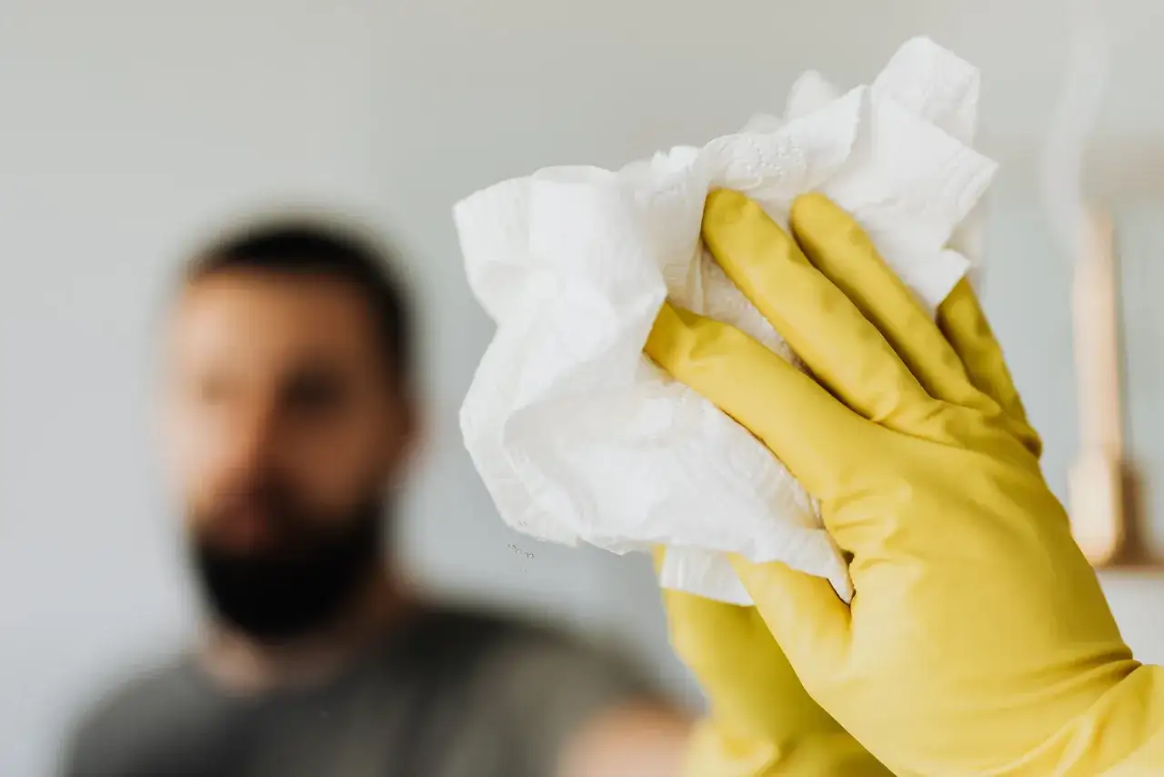Gelbe Handschuhe reinigen Spiegel. Vorsicht bei Putzmittel Schwangerschaft, auf milde Produkte achten.