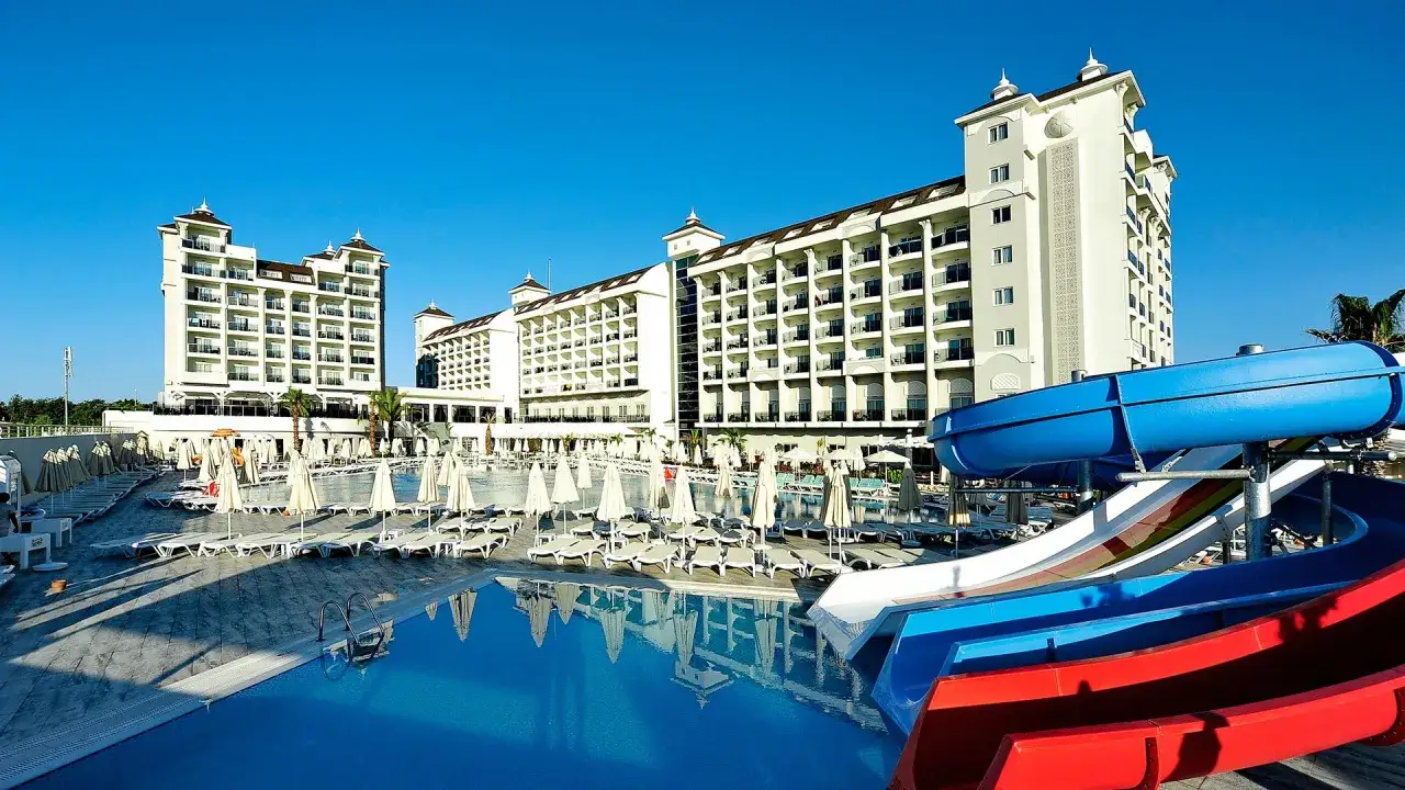 Wspaniały lago hotel z basenem i zjeżdżalniami wodnymi, otoczony leżakami i parasolami. Idealne miejsce na wakacje.