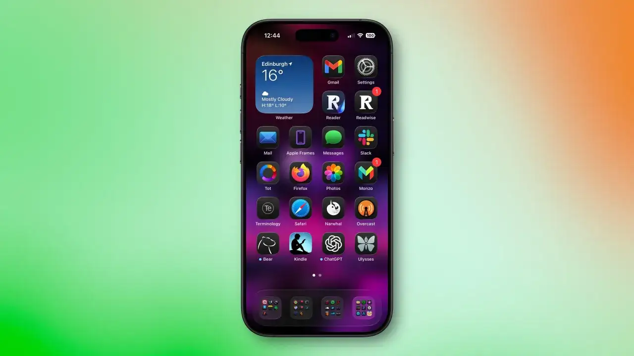 Ekran iPhone'a z ikonami aplikacji, widżetem pogody i paskiem stanu. W tle widać gradient zieleni i pomarańczy, sugerujący odświeżanie aplikacji w tle iPhone.