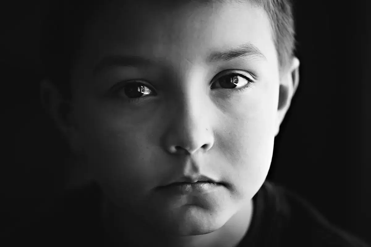 Intensywne spojrzenie chłopca w czarno-białym portrecie. Jak zrobić portret, by uchwycić takie emocje?