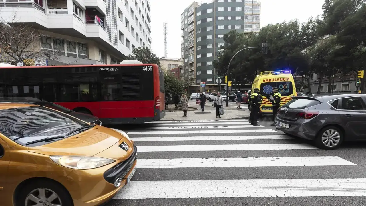 Ambulancia y polic&iacute;a en cruce peatonal, donde se producen m&aacute;s atropellos a peatones. Un autob&uacute;s y coches esperan.