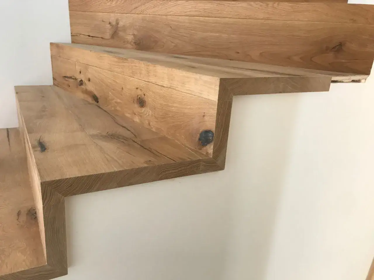Escalier en bois massif, aspect brut et naturel, parfait pour un projet de rénover escalier bois. Les marches sont épaisses et robustes.