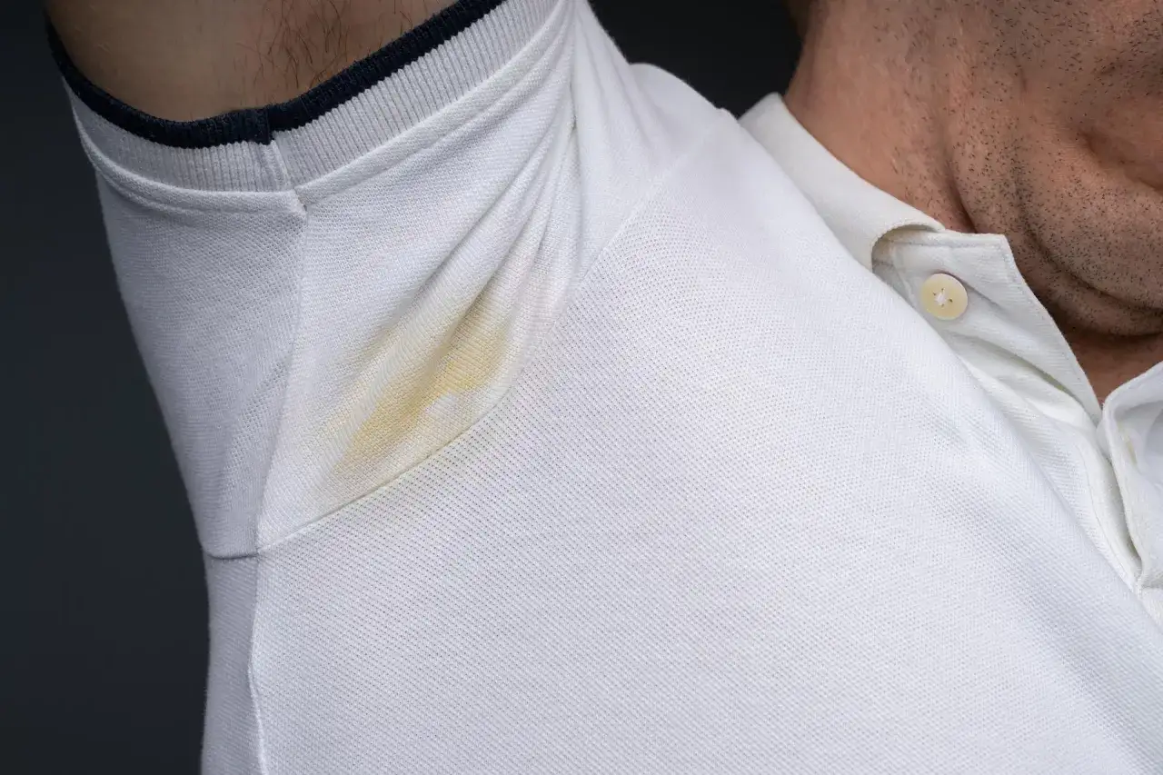 Żółte plamy potu pod pachami na białej bluzce polo. Dowiedz się, jak sprać żółte plamy z białej bluzki, by znów wyglądała jak nowa.