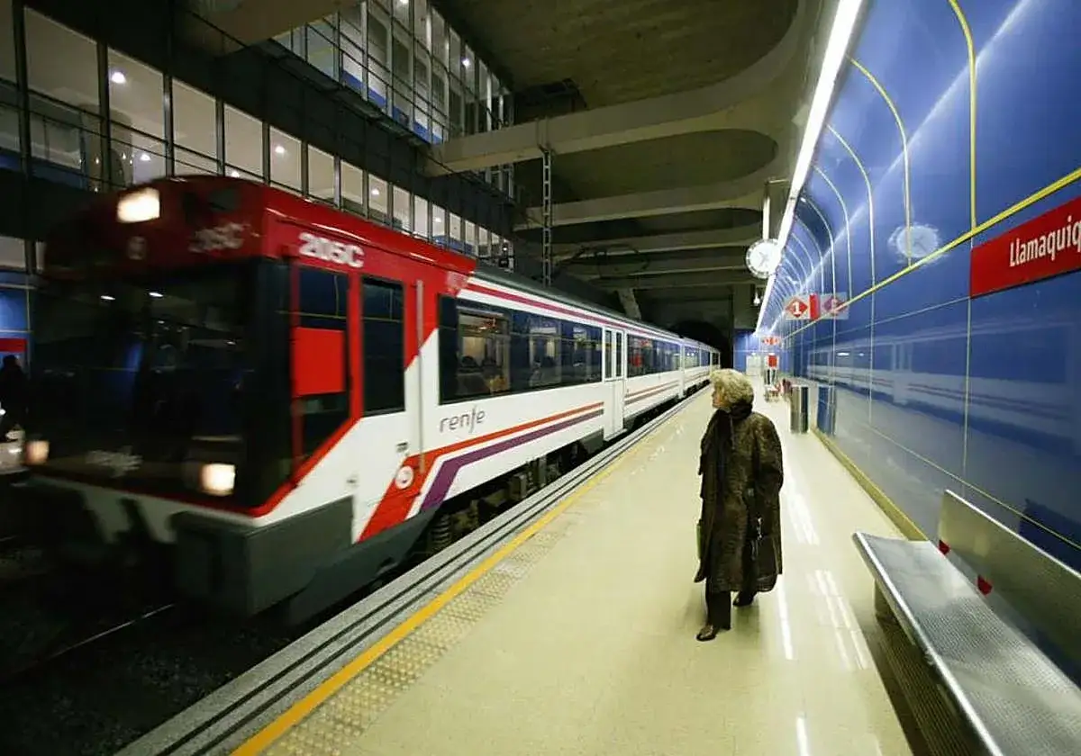Una mujer espera en la estaci&oacute;n de Llamas, lista para tomar el tren que la llevar&aacute; de Valencia a Asturias.