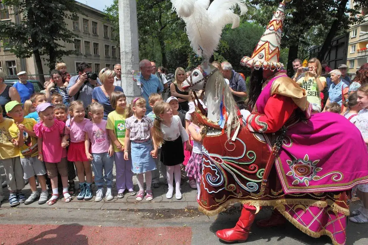 Dzieci z zaciekawieniem oglądają Lajkonika, jak z legendy dla dzieci, podczas barwnego pochodu.