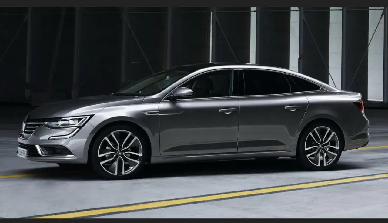 Grå Renault Talisman, en elegant sedan, står parkerad. Kanske ett problem med denna bil?