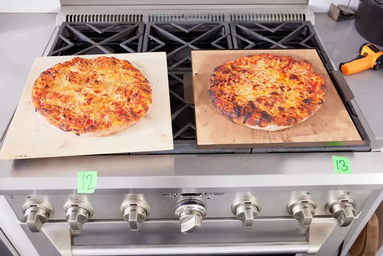 Två pizzor på en spis. En på en pizzasten, den andra på ett pizzastål.