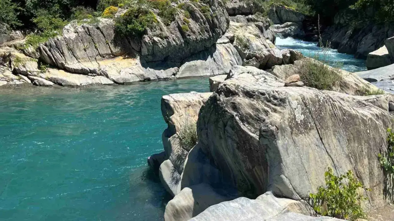 Río turquesa serpentea entre rocas erosionadas. Un lugar idílico para leer reseñas de la poza del molino.