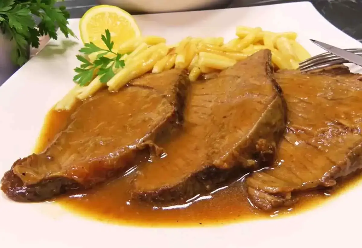 Pyszne bitki wołowe w sosie własnym, podane z makaronem i plasterkiem cytryny. Idealny przepis na obiad.