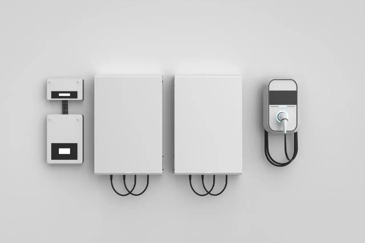 System magazyn energii czy warto? Dwa białe moduły i ładowarka do pojazd&oacute;w elektrycznych na ścianie.