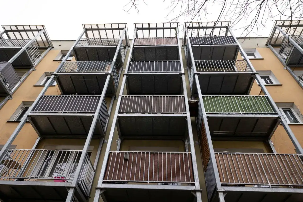 Dobudowa zewnętrznych balkonów do bloków z wielkiej płyty – metalowe konstrukcje z ażurowymi balustradami i zadaszeniami.