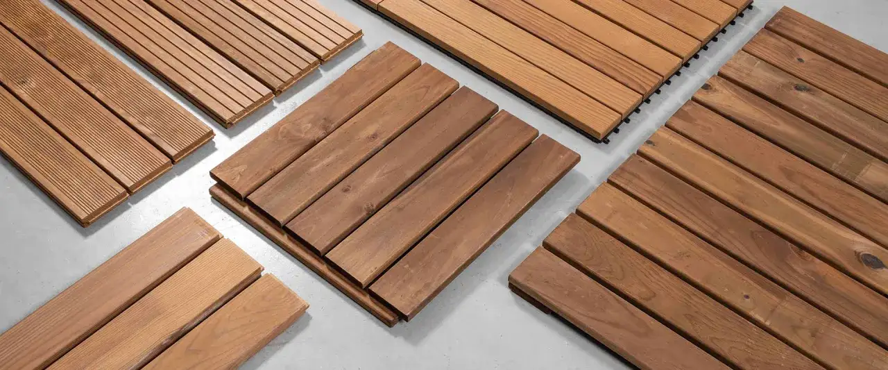 Varias muestras de tarima de madera, algunas con ranuras finas y otras lisas, listas para instalar.