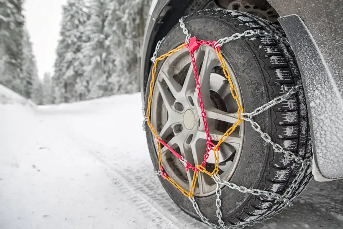 Gomma ghiaccio con catene montate su un'auto su una strada innevata, per affrontare il ghiaccio e la neve.